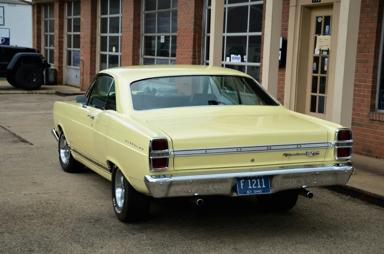 a yellow station wagon sits in front of a building