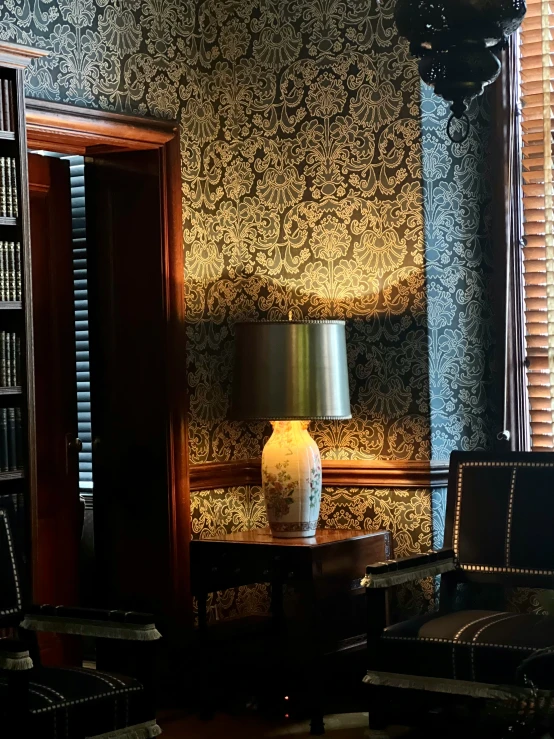 a lamp sitting next to a chair and book case