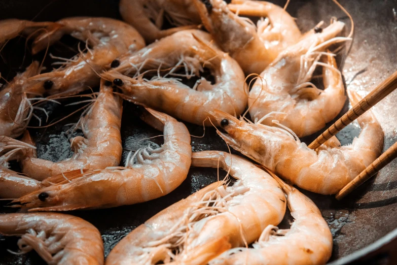 an old frying pan full of shrimp sitting on the kitchen floor