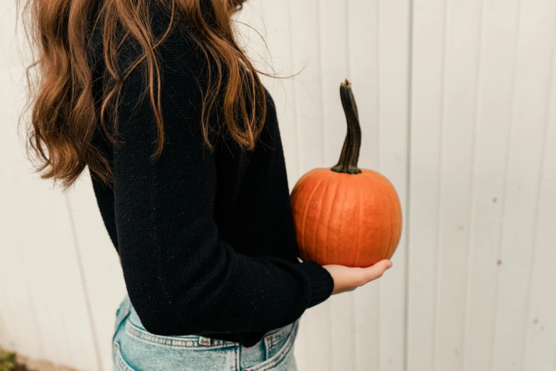 a woman holding a pumpkin in her hands