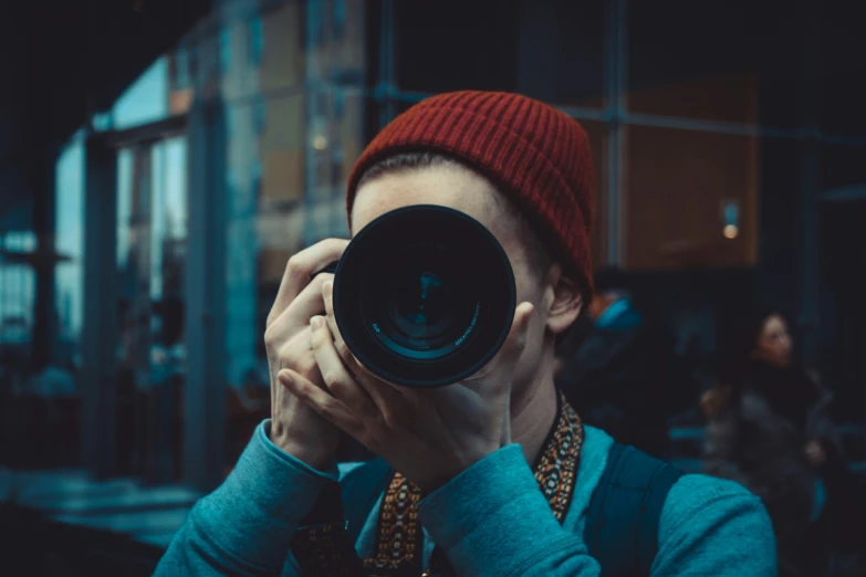 a man taking a po of himself with a large lens