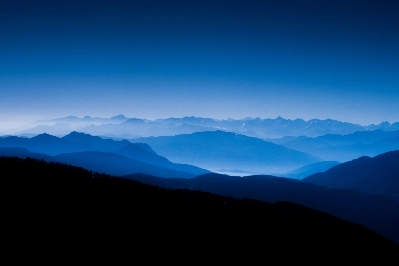 a dark blue mountain with mountains as seen from below