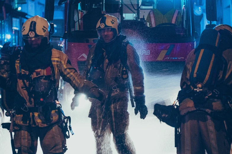 two firefighters with fire gear in the middle of a street