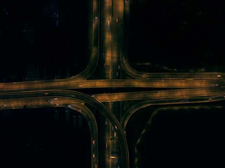 overhead view of traffic intersecting and the road lights at night