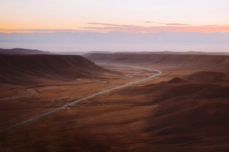 a small car traveling in the middle of nowhere