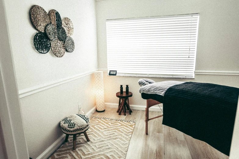 the view into a bedroom that has a bed, a blanket and two stools