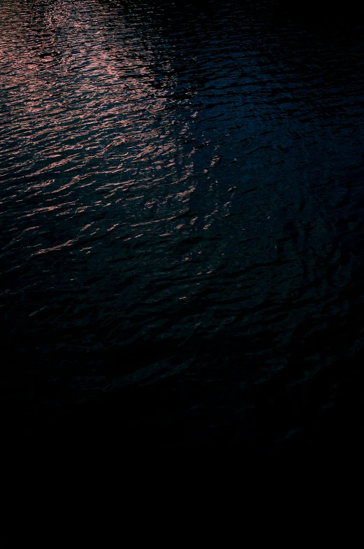 a black background with a red sunset reflected on the water