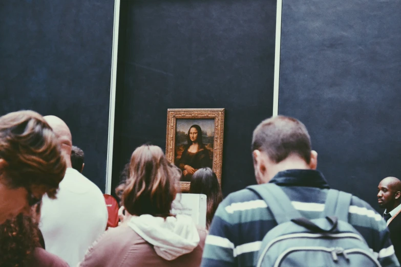 people viewing a painting on the side of a building