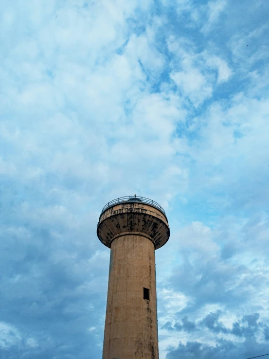 a large cement tower standing in front of a cloudy sky