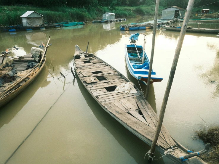 several boats are floating on the brown muddy river