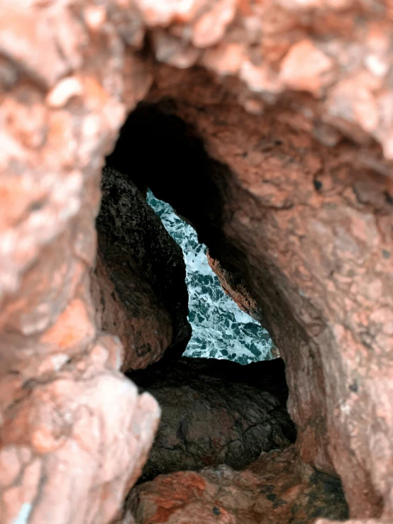 the sea is moving behind a rock formation