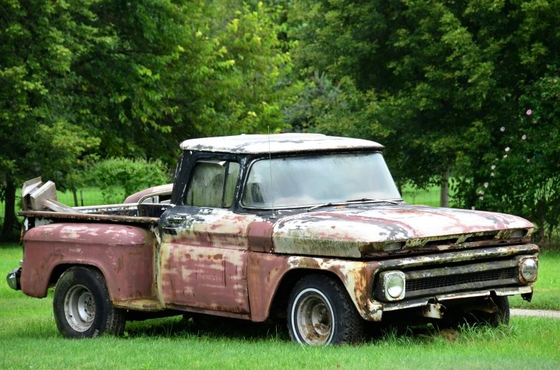 an old truck sitting in a field