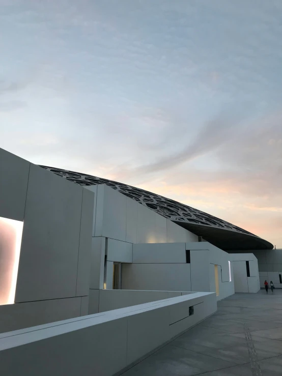 the exterior of a white building on a cloudy day