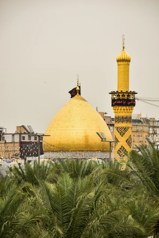 a golden dome on top of a building next to palm trees