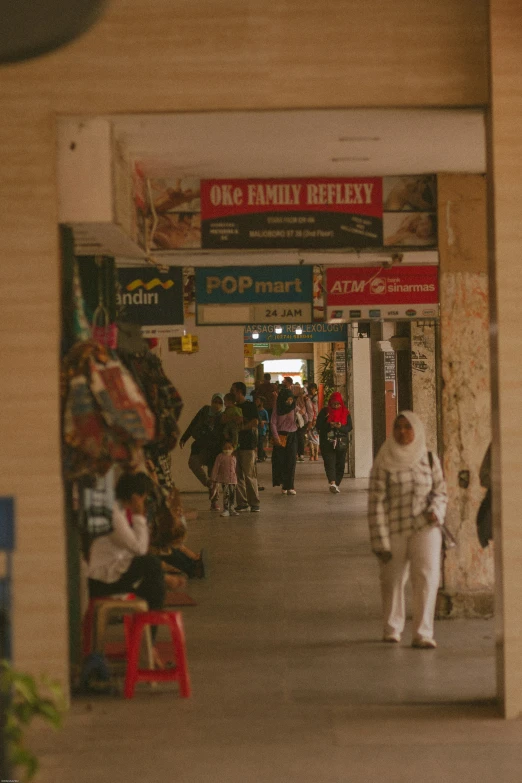 a crowd of people walking on a sidewalk near stores