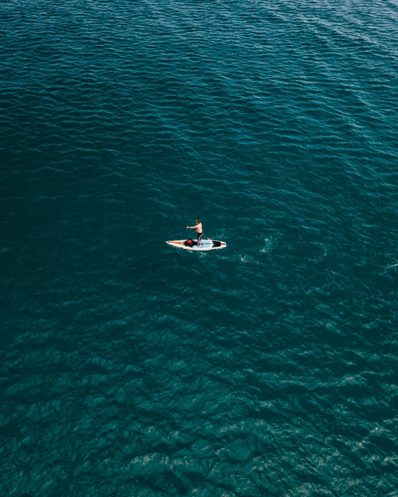 a man riding on the back of a boat in the ocean