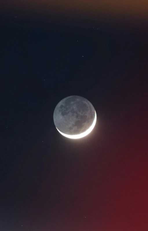 the moon and a distant object against a dark night sky