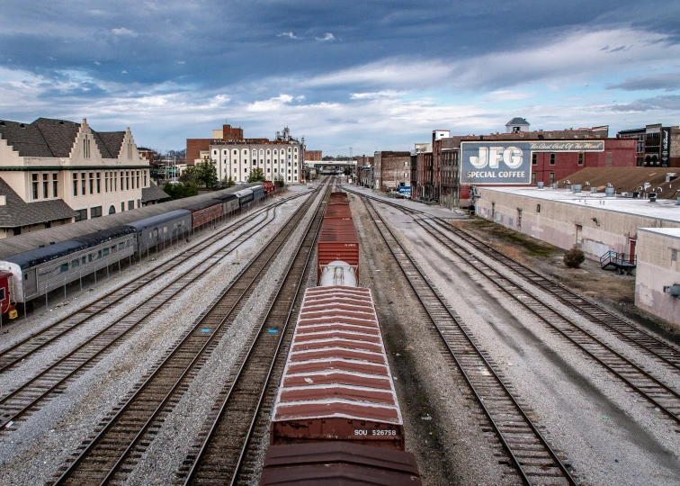 railroad tracks lead through a small town under cloudy skies