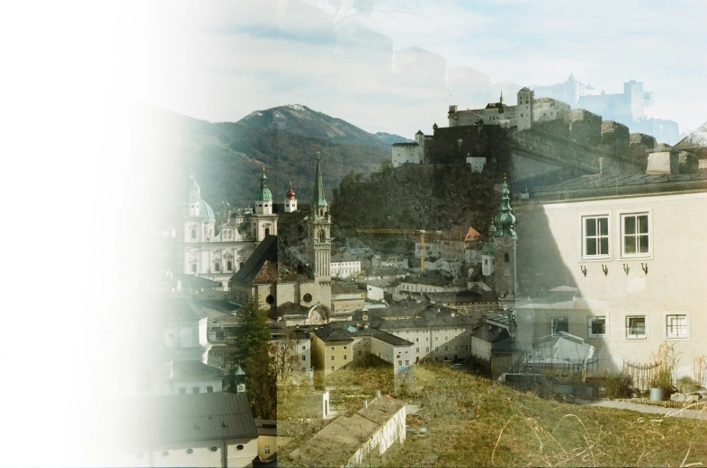 a scenic view of the city in front of mountains