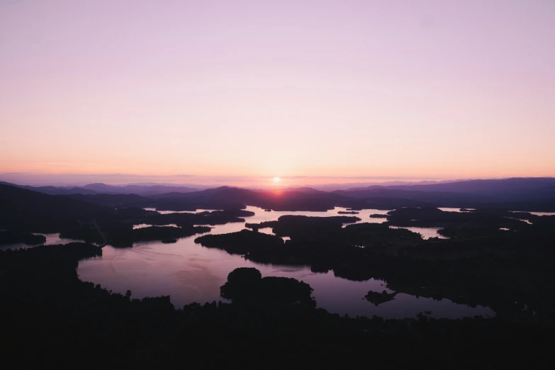 an aerial s of the sun setting over the water