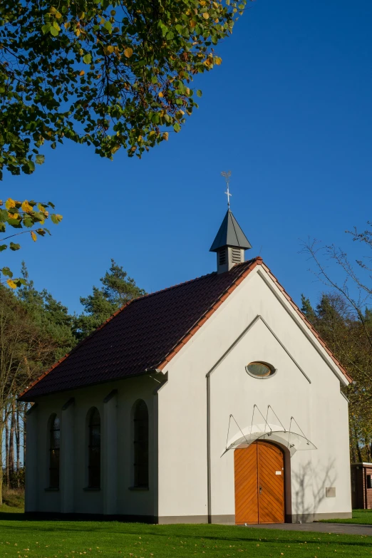 a white church with red door and steeple