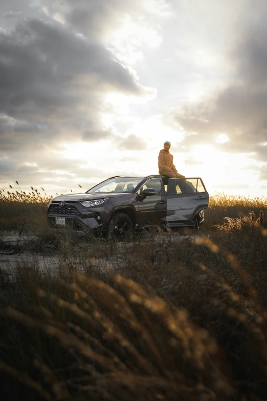 a man standing on the hood of a parked car