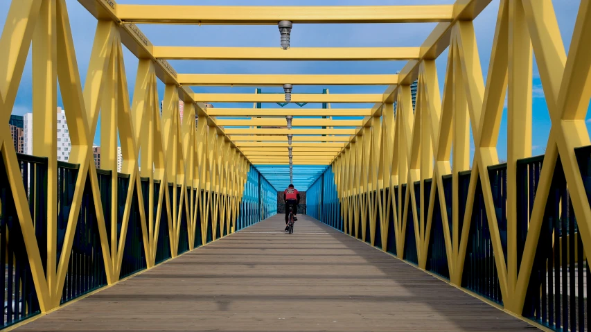 a man that is walking across a bridge with some poles