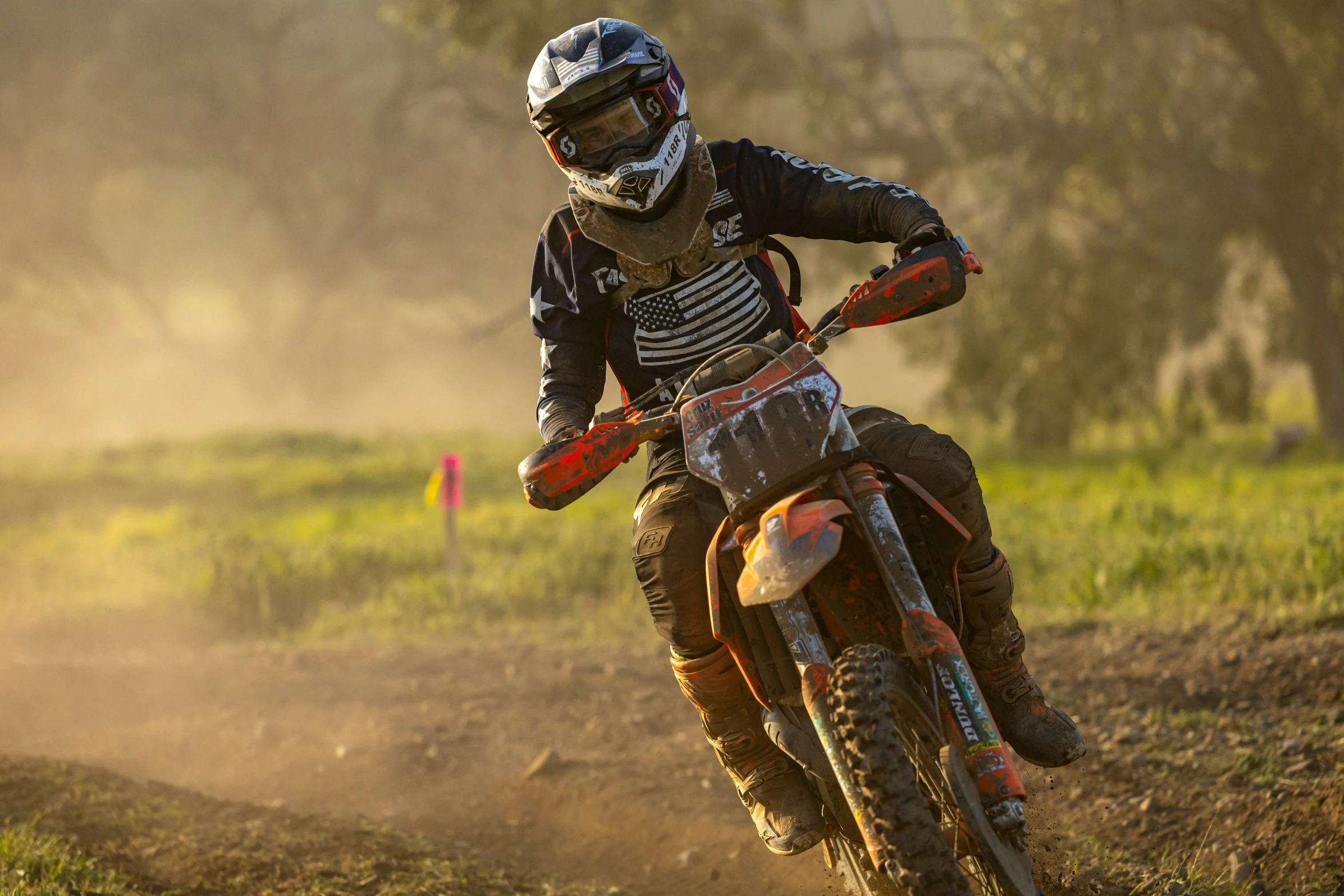 the motocross rider is going down the dirt track