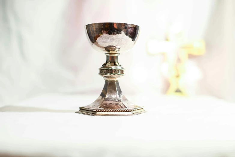 an ornate ss plated chalice is on a white surface