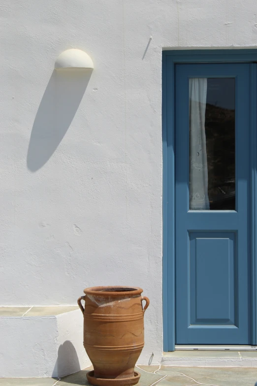 a very big pot sitting outside a white building