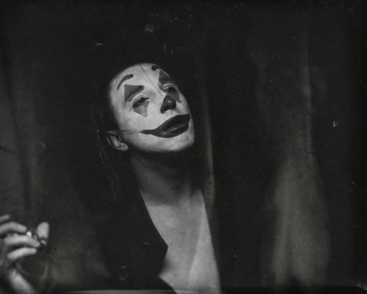 woman with makeup sitting on table holding cigarette