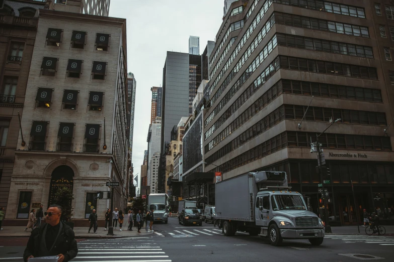 trucks move along the streets of a city in a hazy day