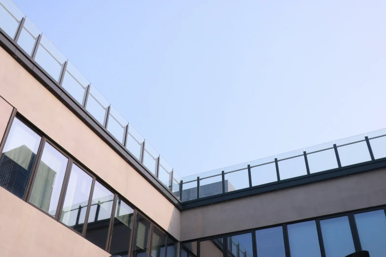 a side view of a building with windows and a fence on top