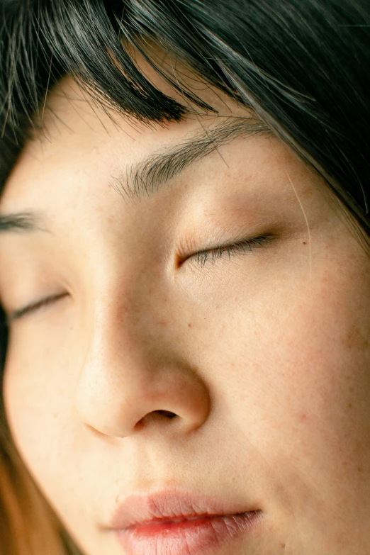 a woman with her eyes closed is wearing a necklace