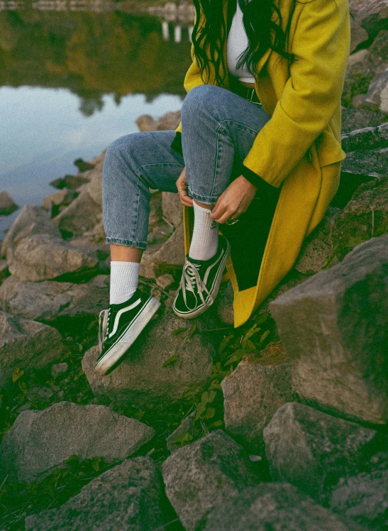 a woman sitting on a rock with the background blurry