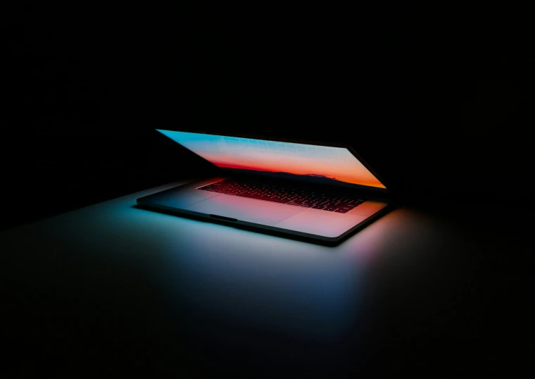 a laptop is sitting on a table with its light reflected off