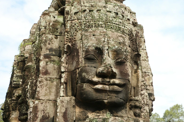 a face made of stone is seen at the base of a building