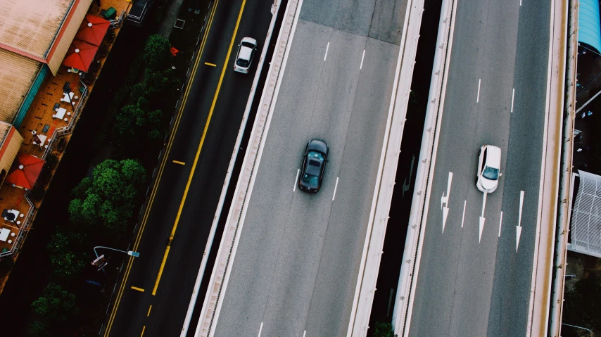 cars drive down a street from an aerial view