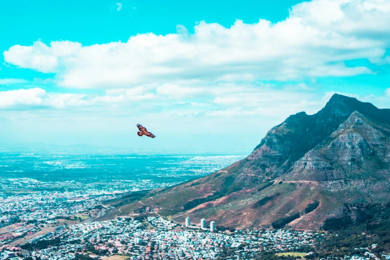 a red airplane flying in the sky over a city