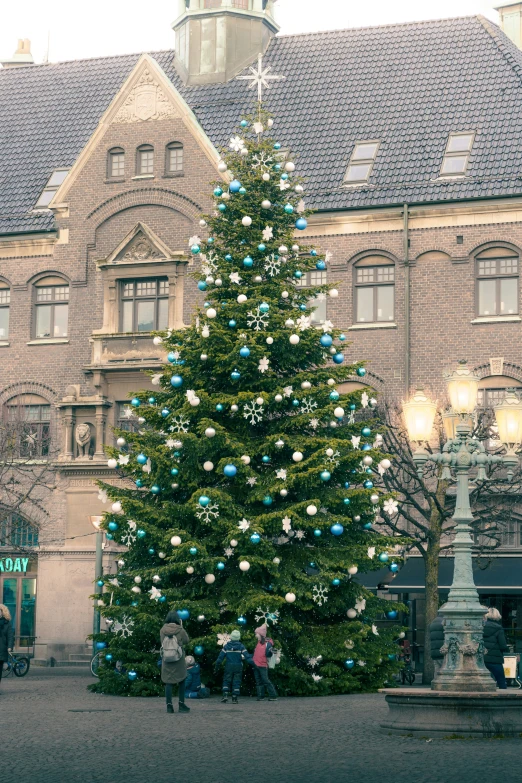 a large christmas tree in front of a tall building