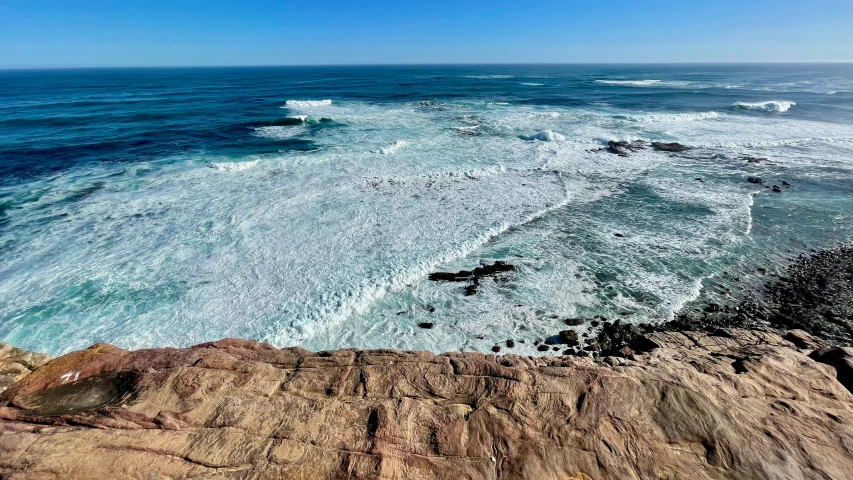 waves break on the rocks and are near the water