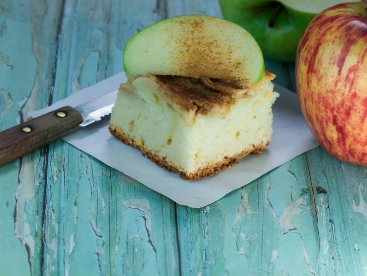 an apple on top of a table with a knife