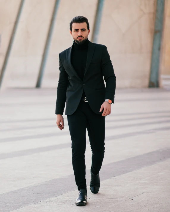 man with beard walking down the street with a black jacket and vest