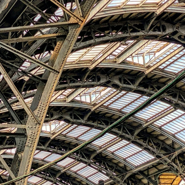 a train station with large windows and metal beams