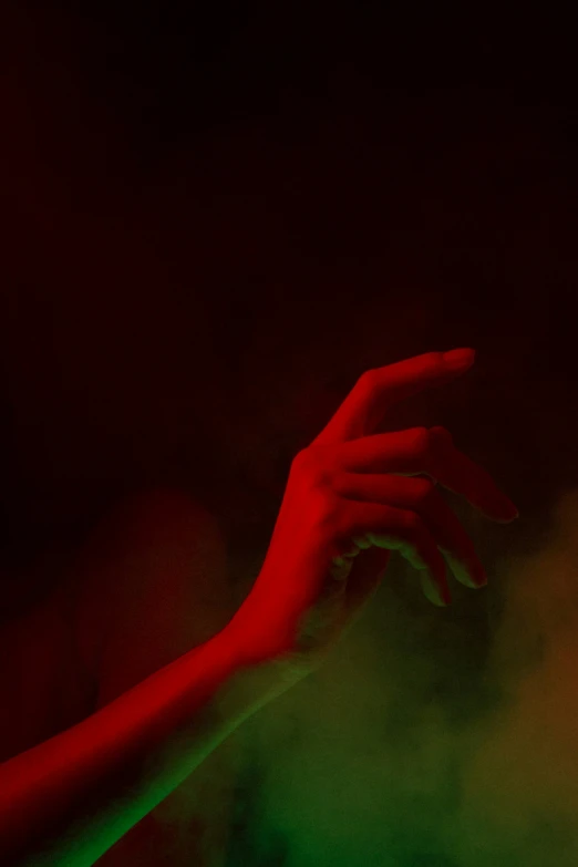 a red hand reaching out from behind green