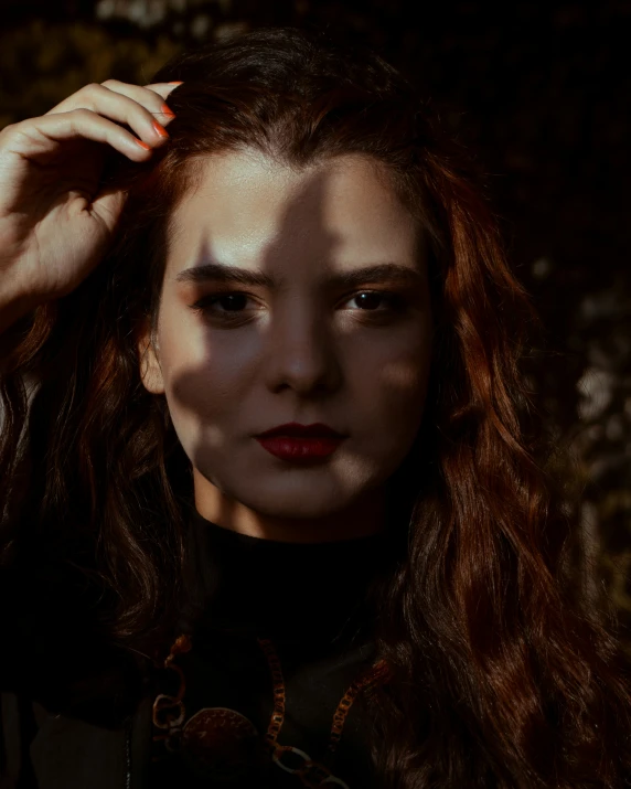 a woman with dark makeup and red lip is posing