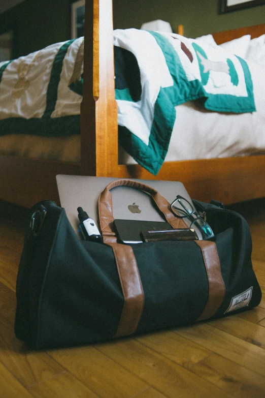 bag and laptop lying on floor near bed