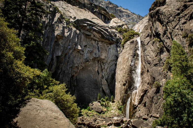 water falls falling from a high mountain to a lush forest