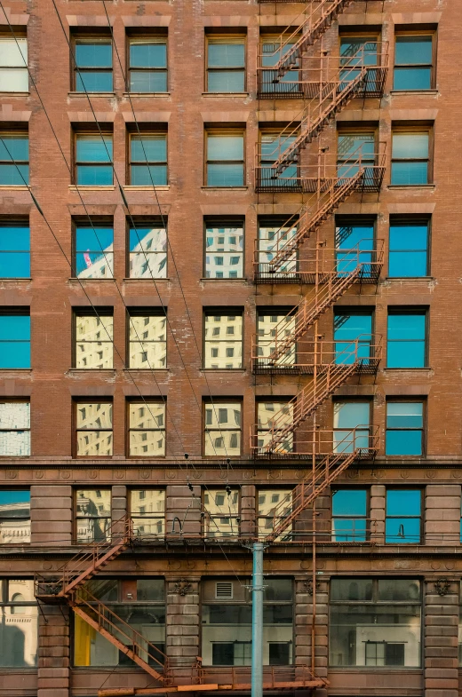 a fire escape is attached to a large brown brick building