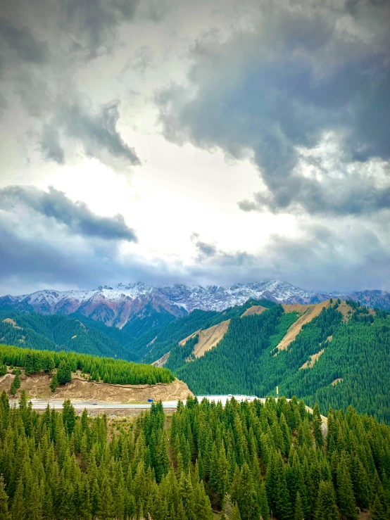 mountain scene with green trees and a big building